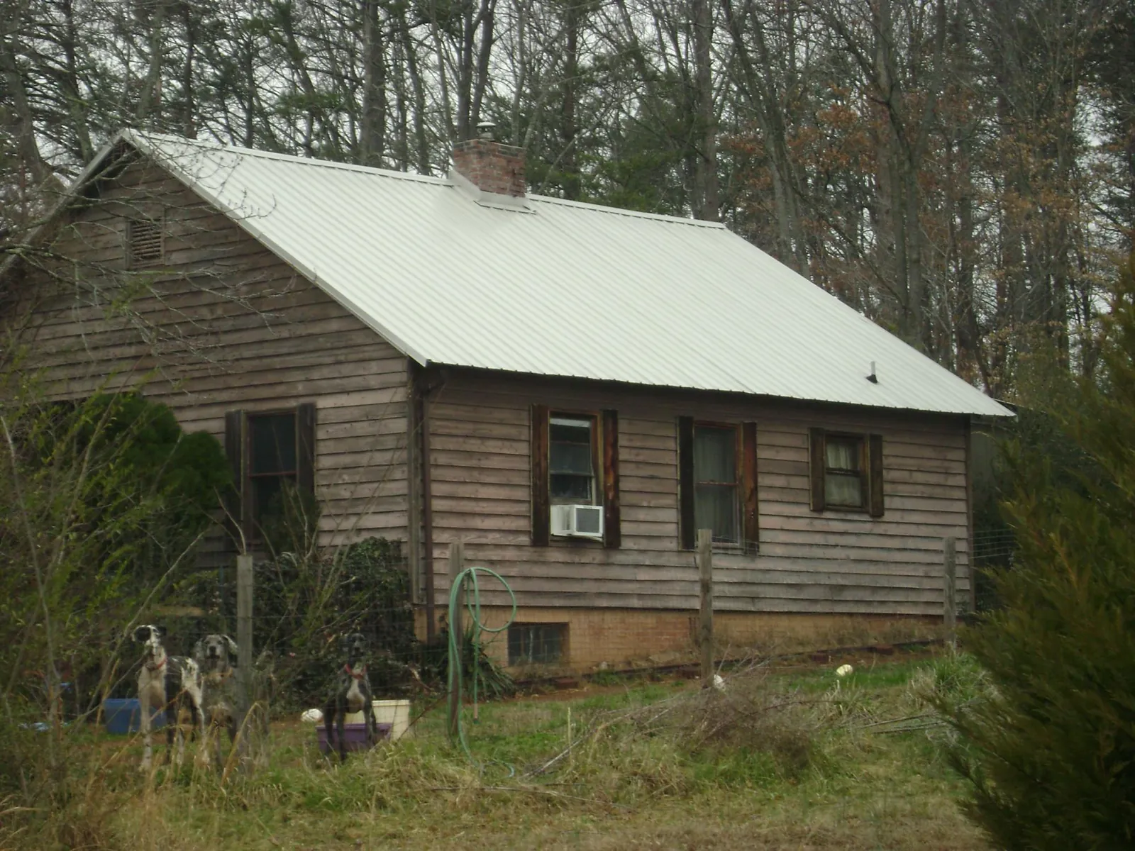 White metal roof on an old wood sided farmhouse, from a Metal Roof Installation job in Mulberry